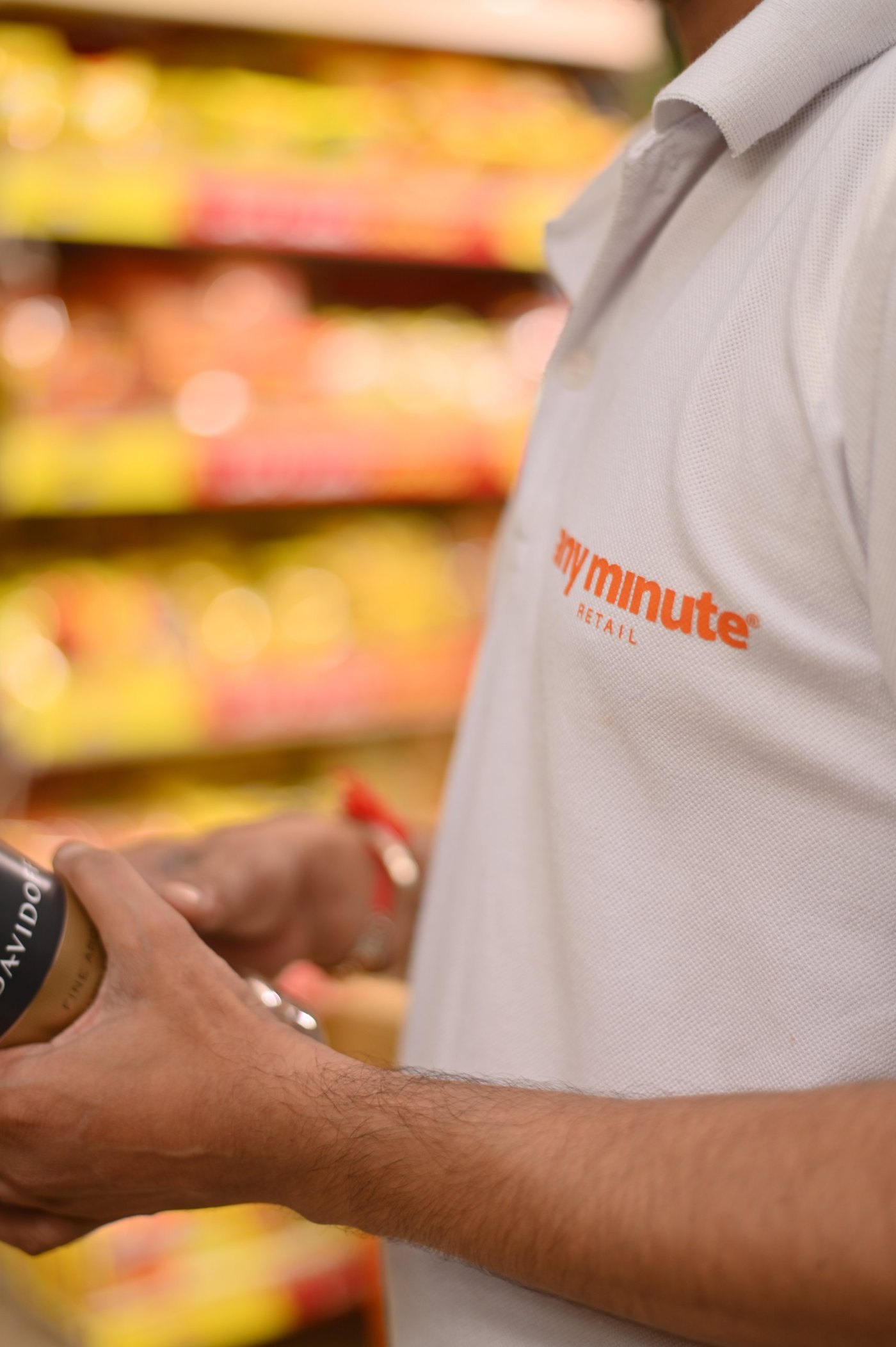 An Any Minute Retail team member holding a product in the store